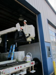 Catherine changing light bulbs in the ceiling of Superior Auto Service.